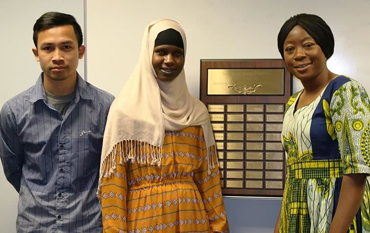 Three Hubbs Center student scholarship winners stand by the award plaques in the Hubbs Center